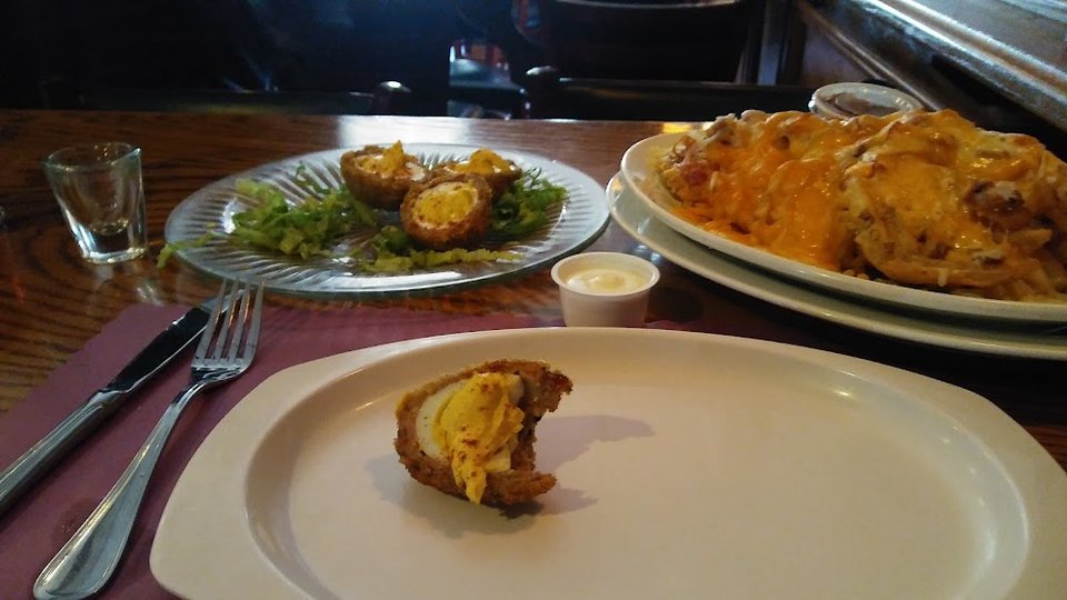 Plated pub food beside a drink.